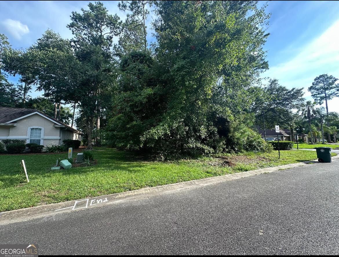 a view of a house with big yard and large trees