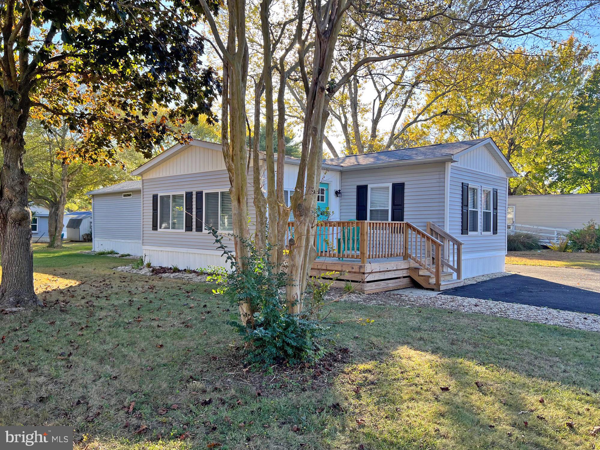 a front view of a house with yard and tree