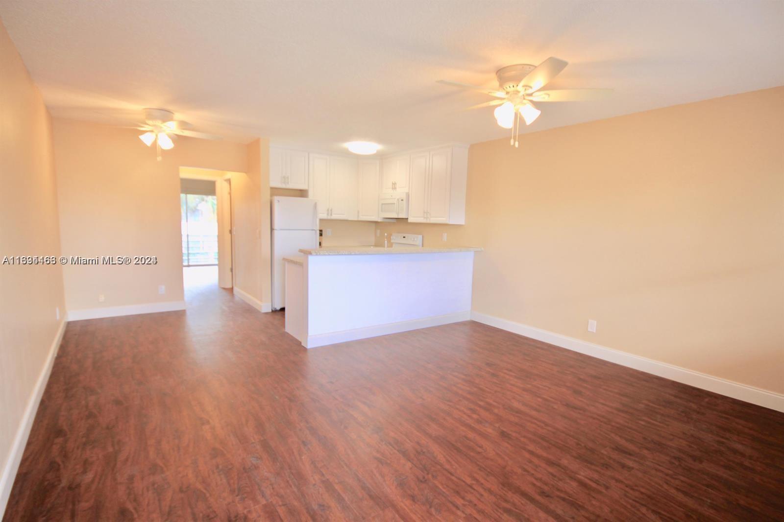 a view of a kitchen with wooden floor and a kitchen