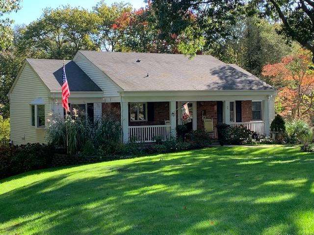 View of front facade featuring covered porch and a front yard