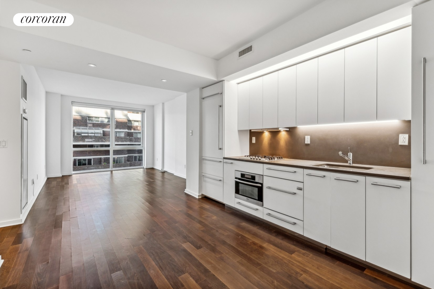 a kitchen with wooden floors and cabinets