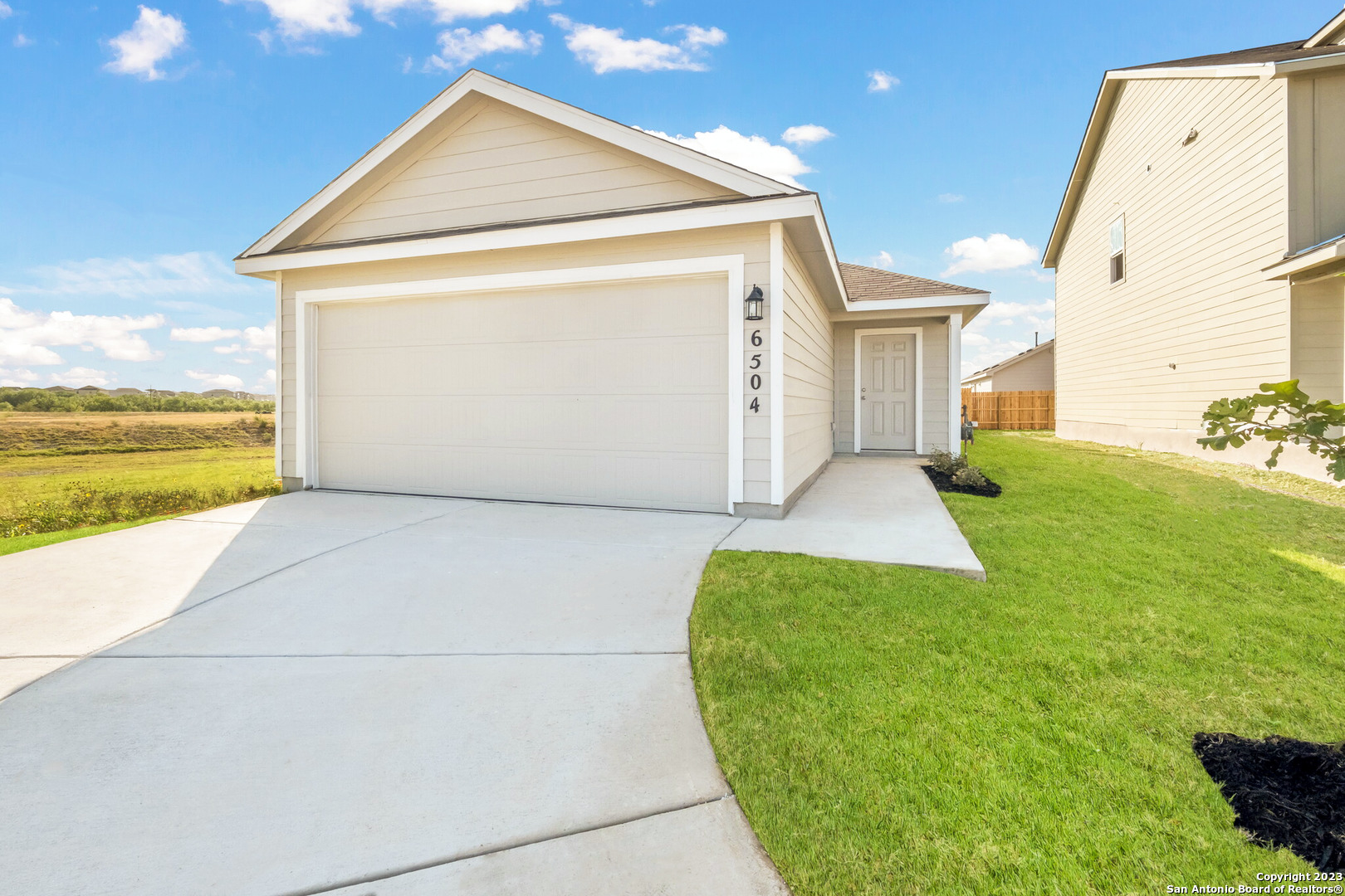 a view of a big house with wooden fence