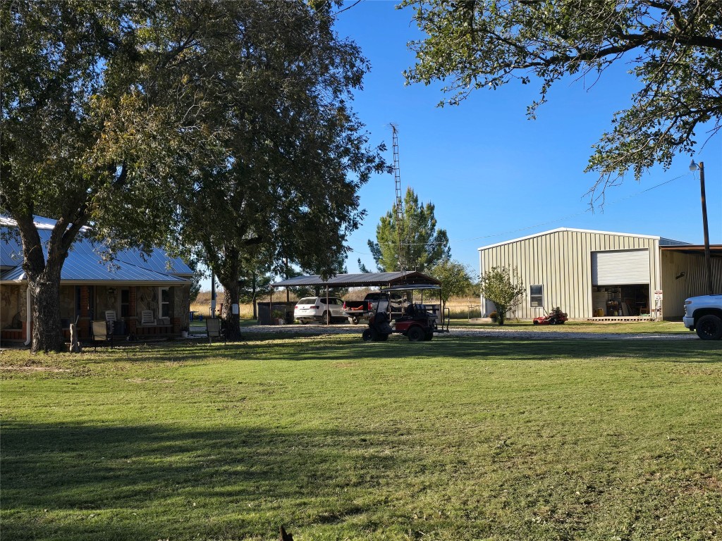 a view of a swimming pool with lawn chairs and a big yard