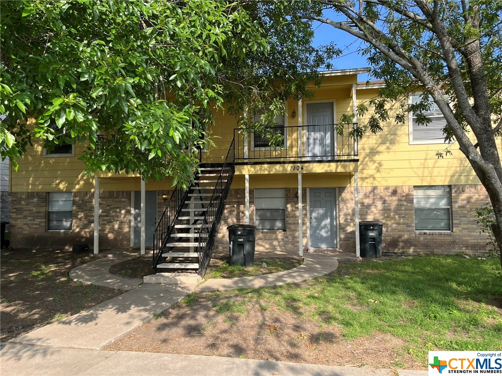 a front view of a house with a tree