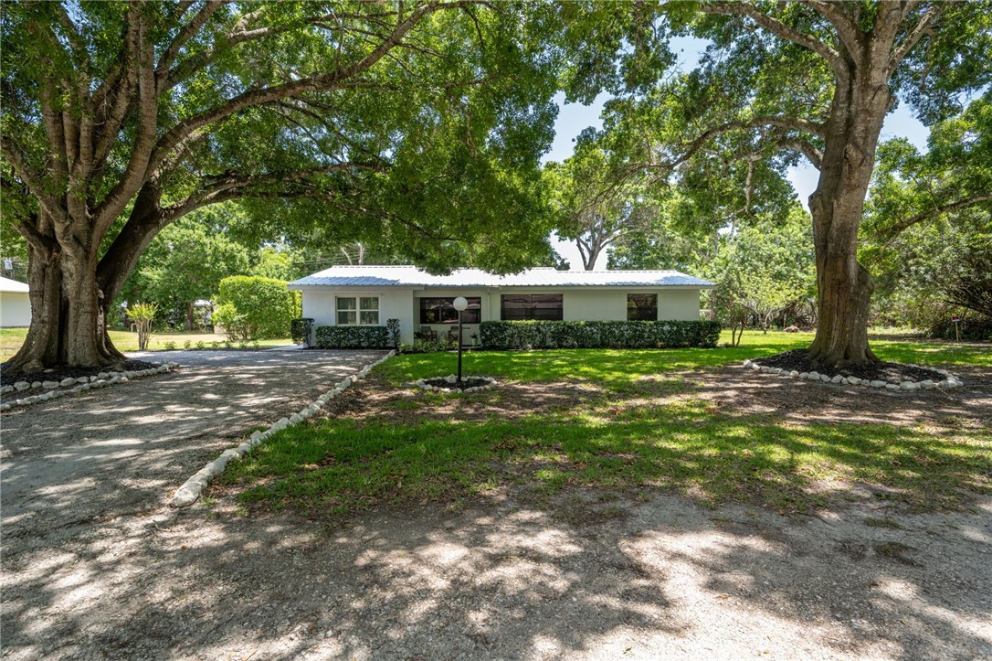 a front view of a house with a yard patio and green space