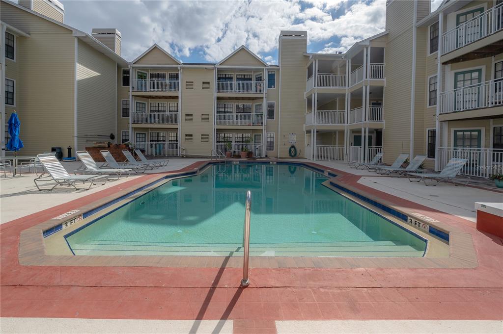 a house view with swimming pool and sitting space