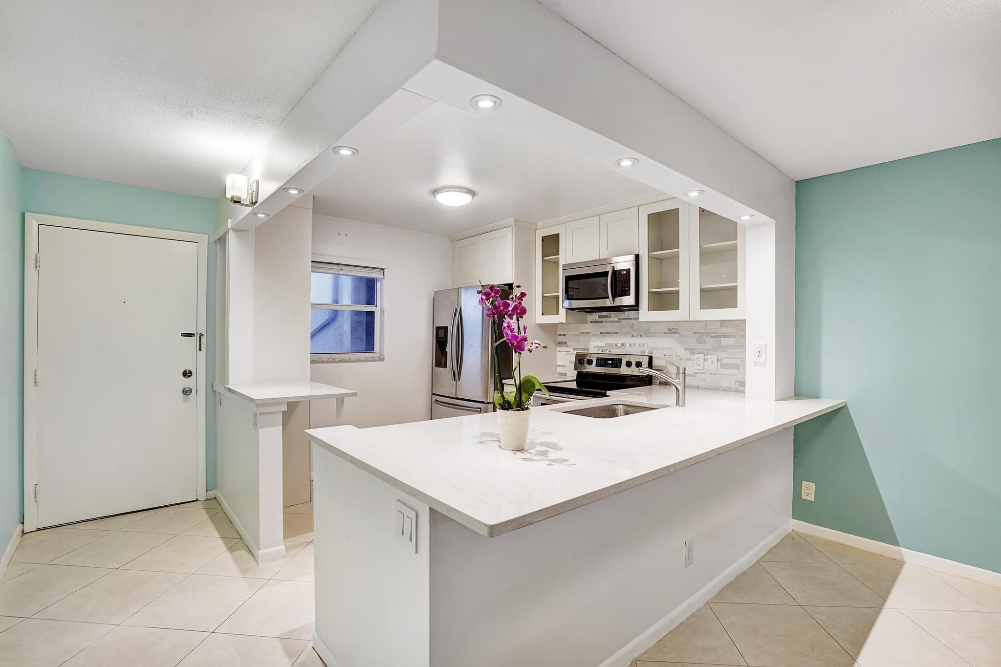 a kitchen with a sink refrigerator and microwave