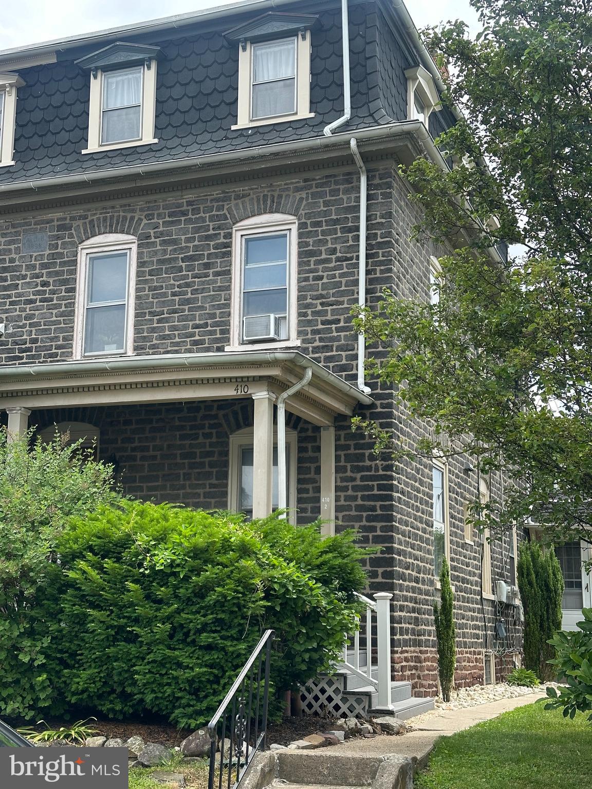 a view of a house with brick walls and plants