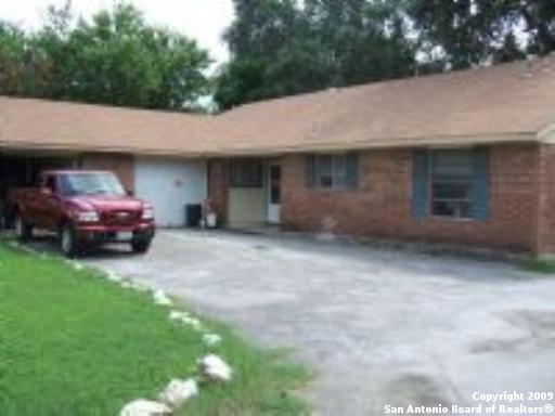 a front view of a house with cars parked