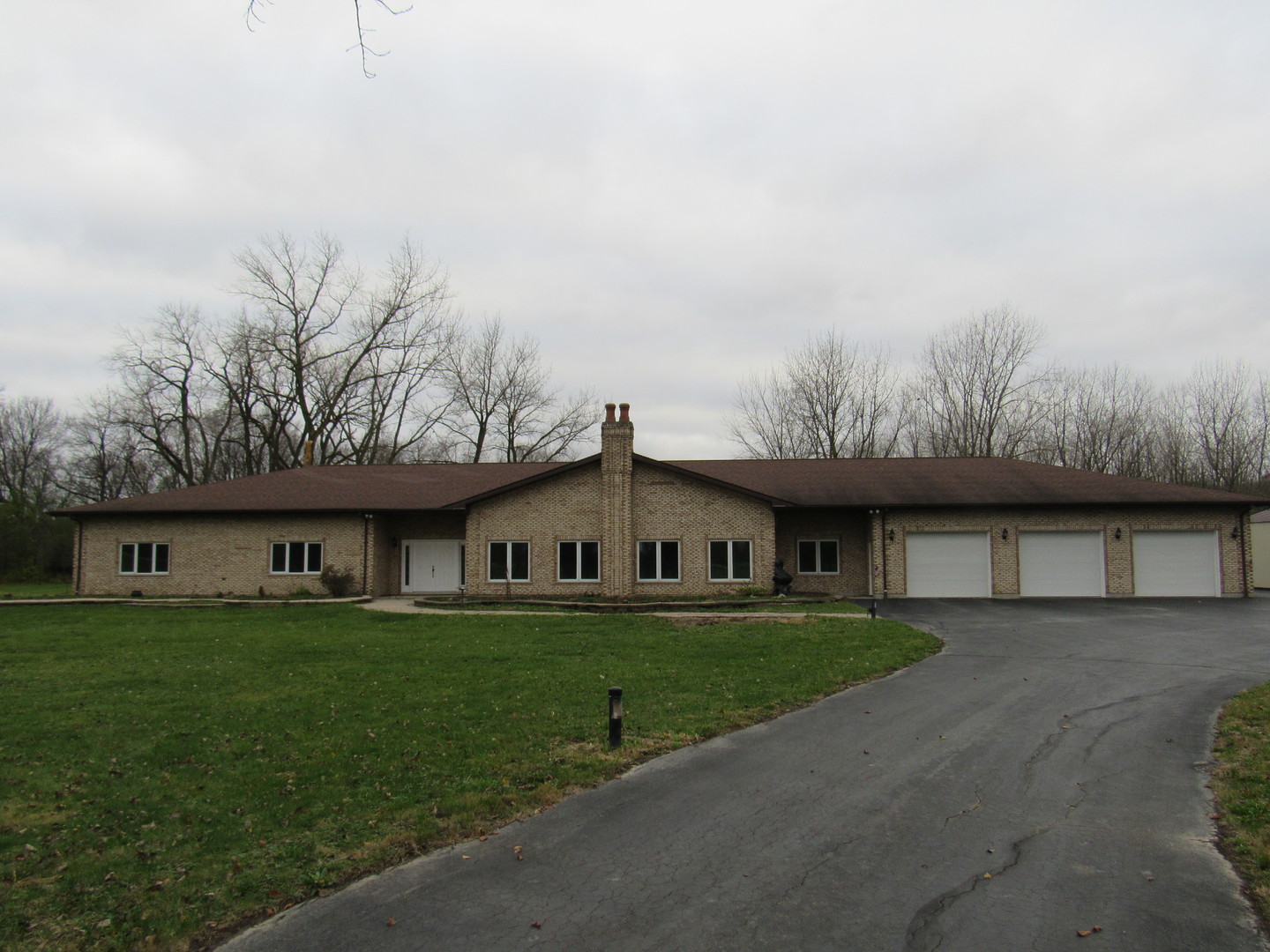 a view of a white house with a big yard and large trees