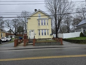 a view of a white house with large windows and a tree