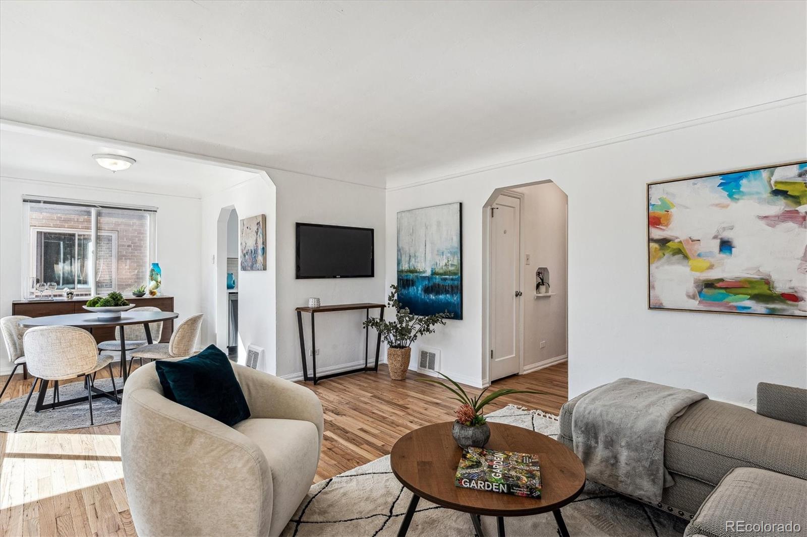 a living room with furniture a flat screen tv and kitchen view