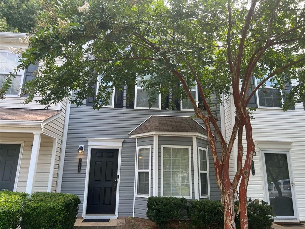 a front view of a house with a tree