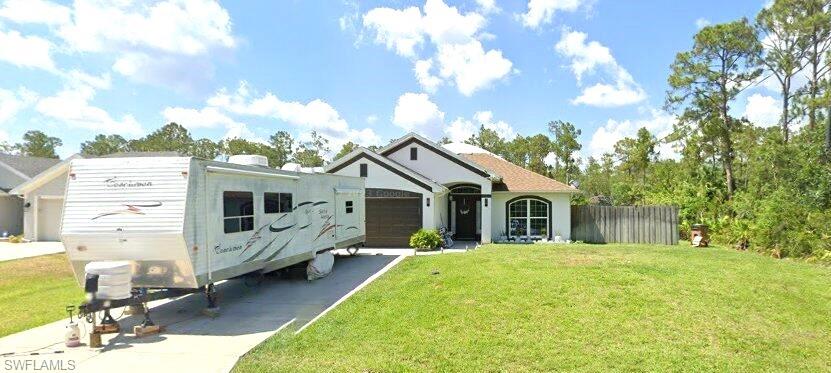 View of front facade featuring a garage and a front yard