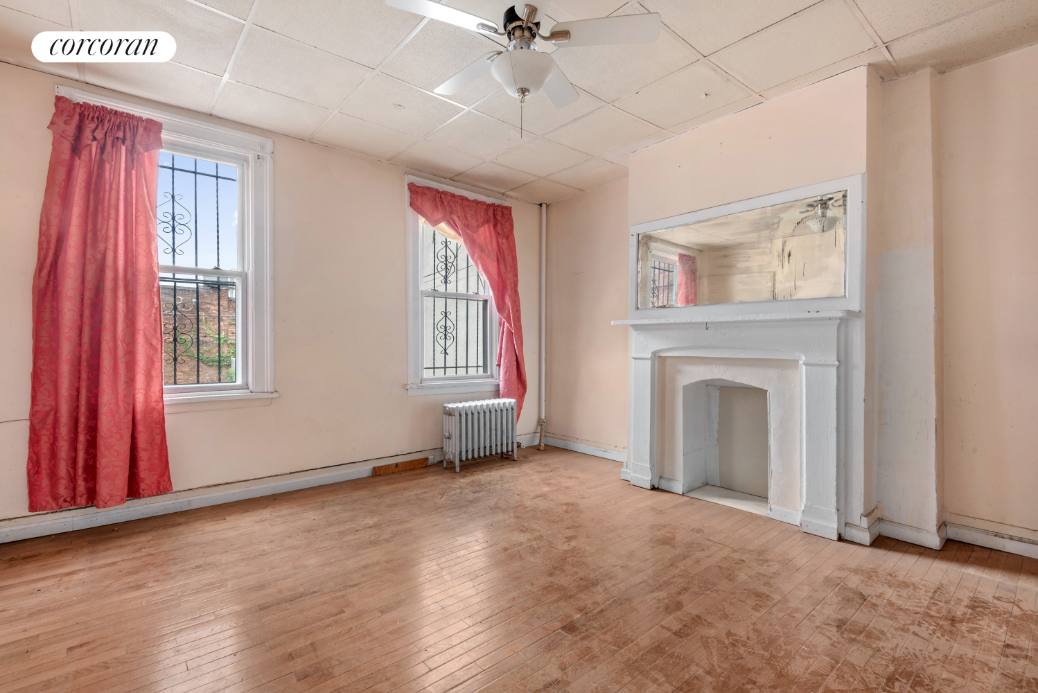 an empty room with windows and fireplace