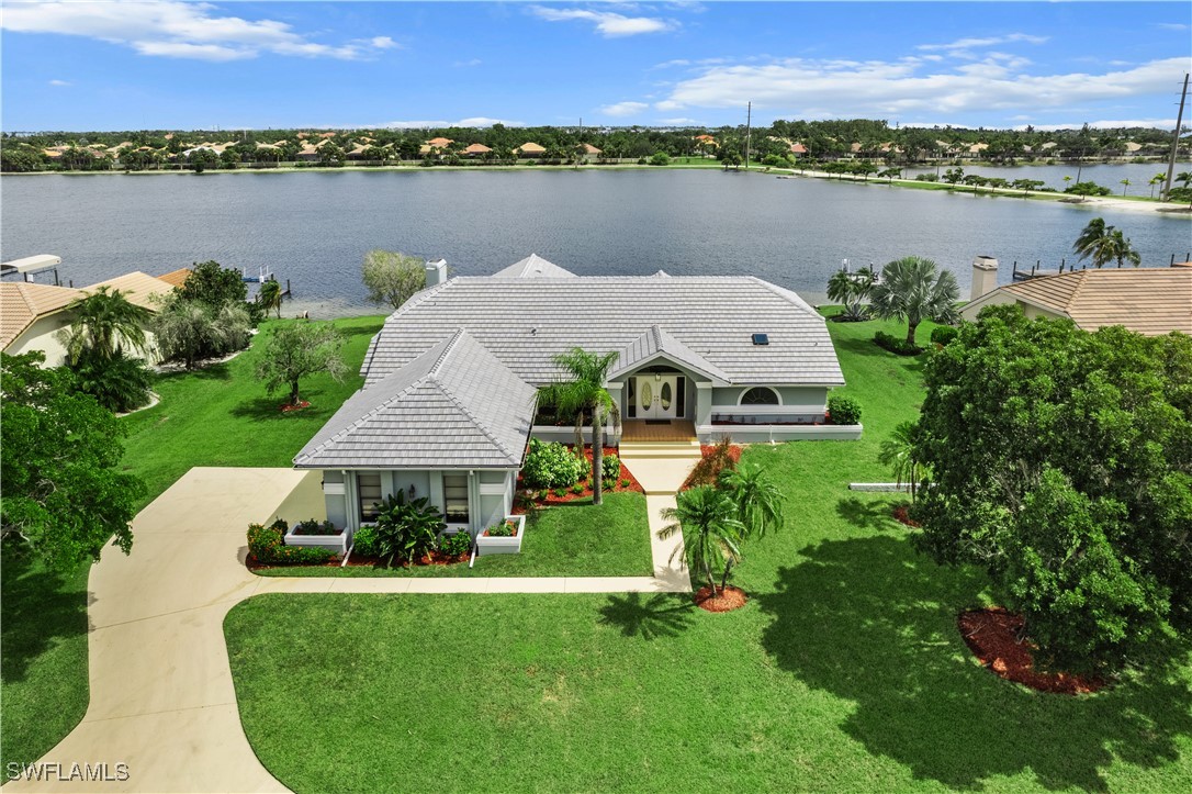 an aerial view of a house with outdoor space and lake view in back