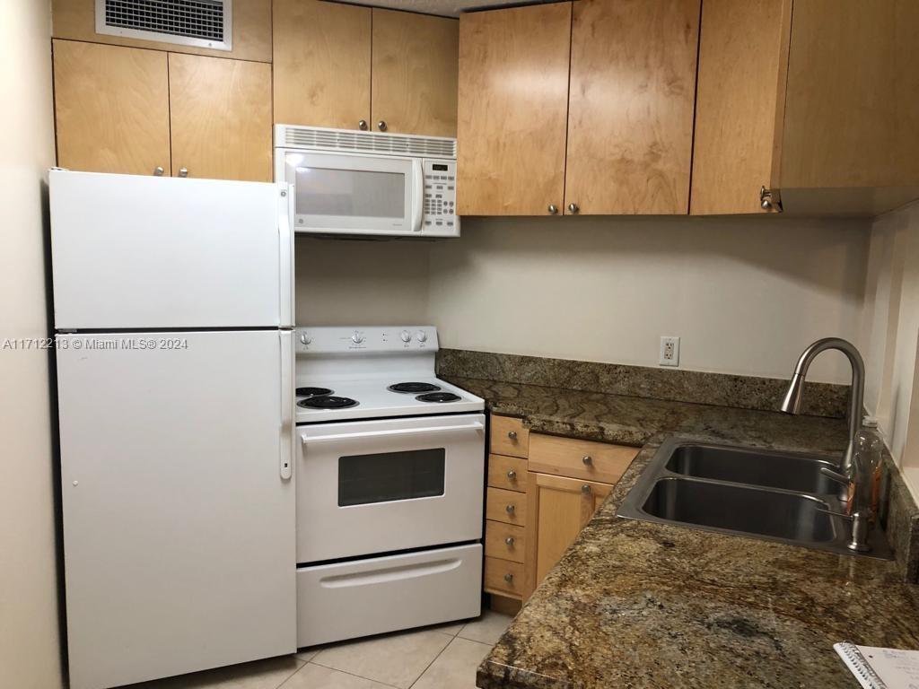 a kitchen with stainless steel appliances granite countertop a stove and a refrigerator