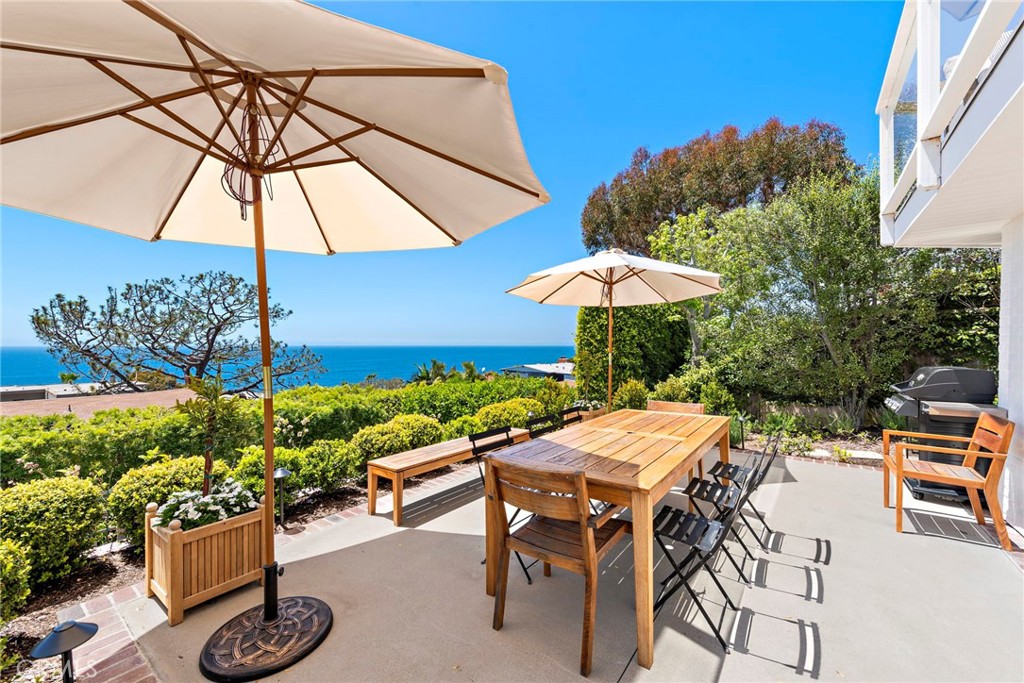 a view of patio with chairs and table under an umbrella