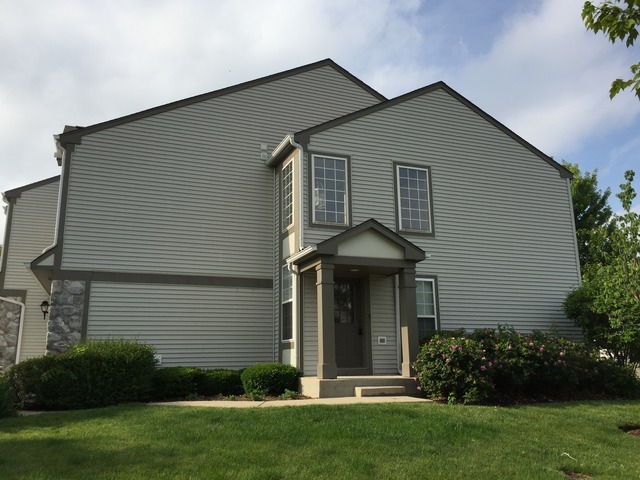 a front view of a house with a garden and plants