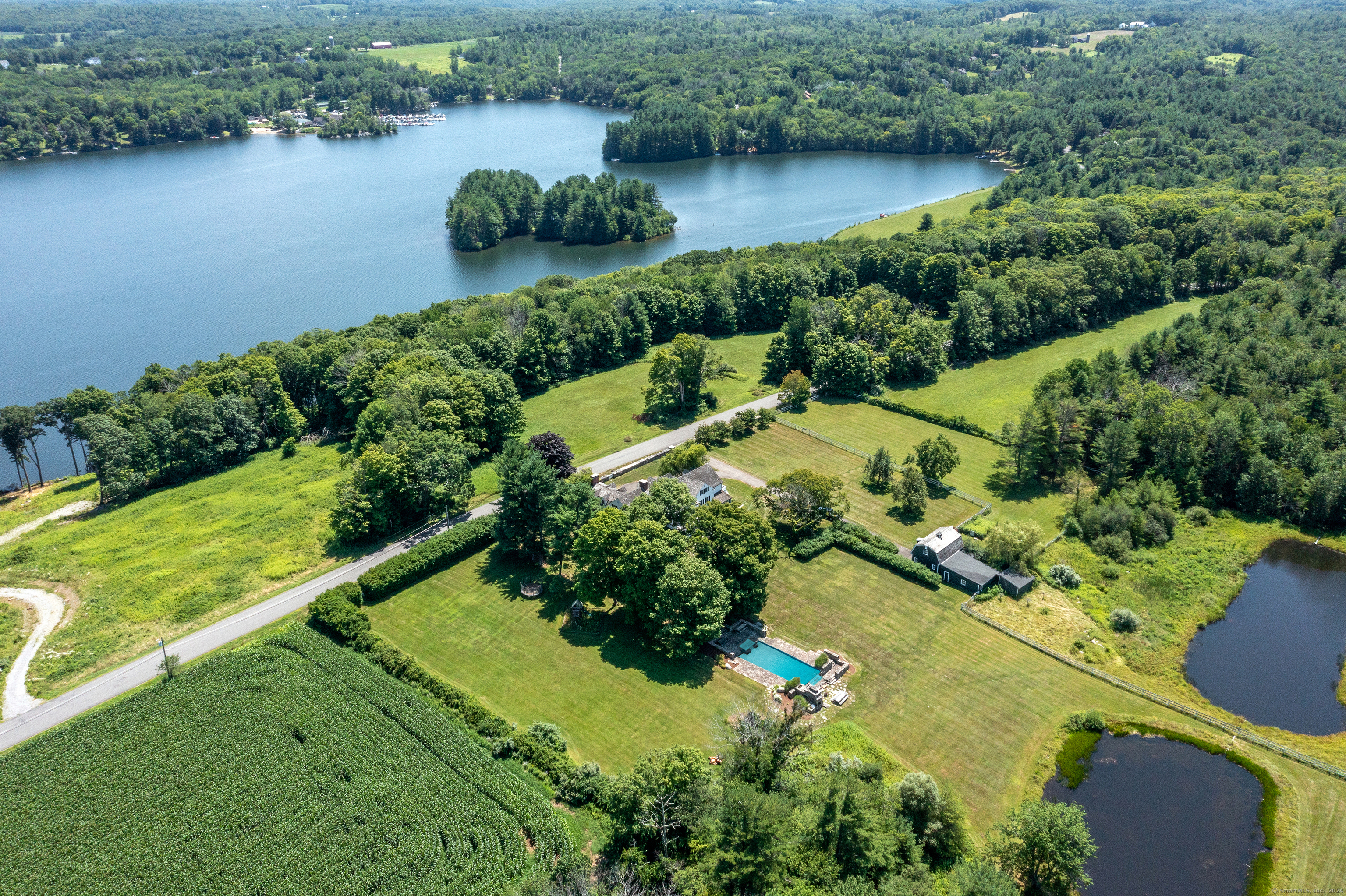 an aerial view of lake residential house with outdoor space and trees all around