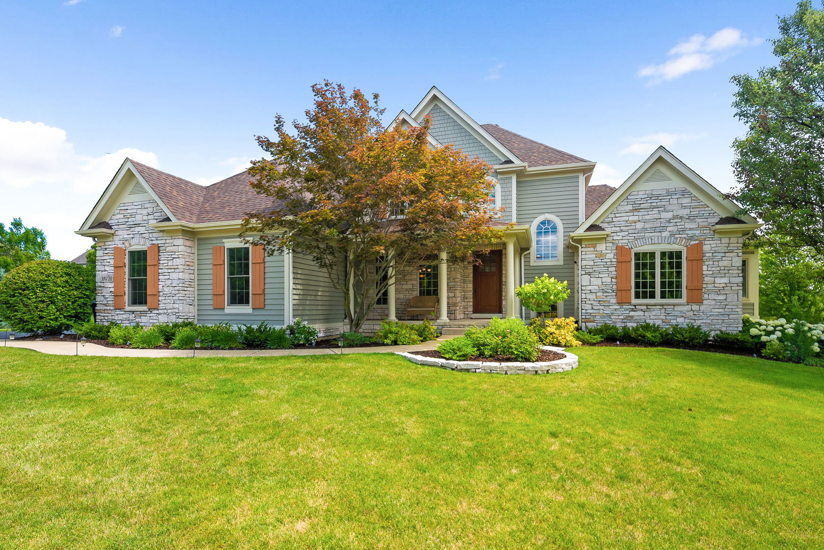 a front view of a house with a garden and yard