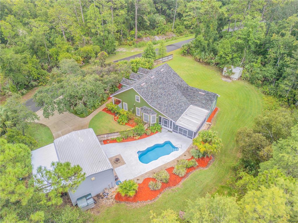 an aerial view of a house with a garden and swimming pool