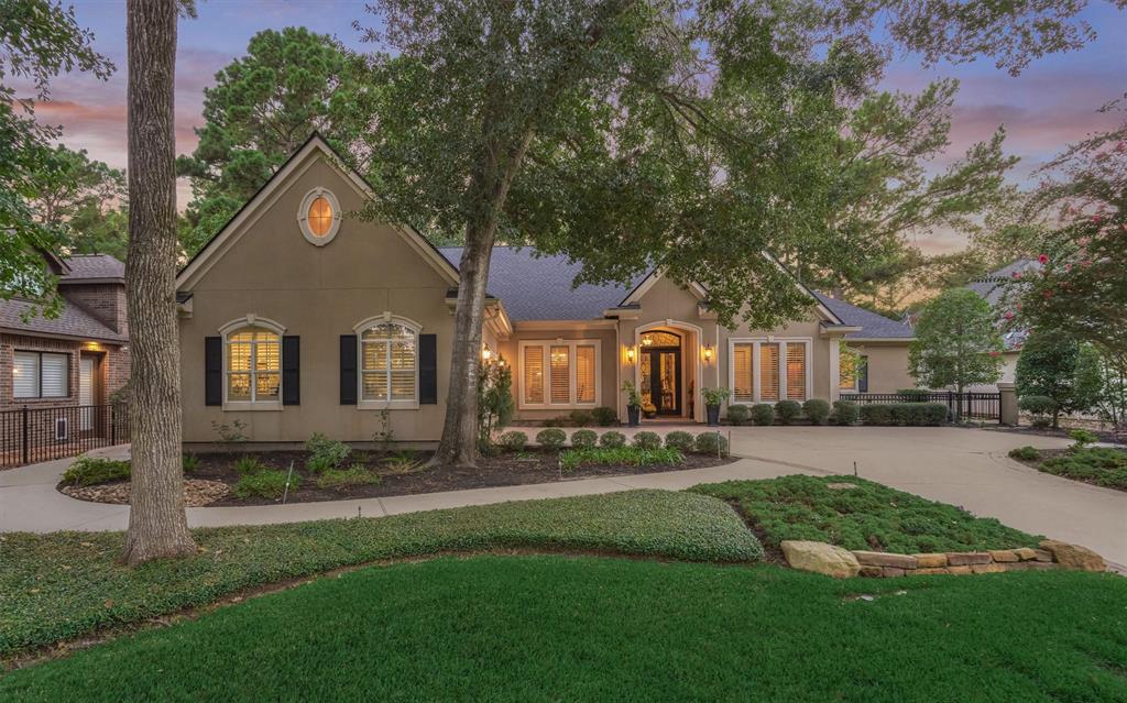 a front view of a house with a yard and trees