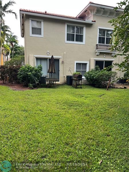 a front view of a house with a garden and trees