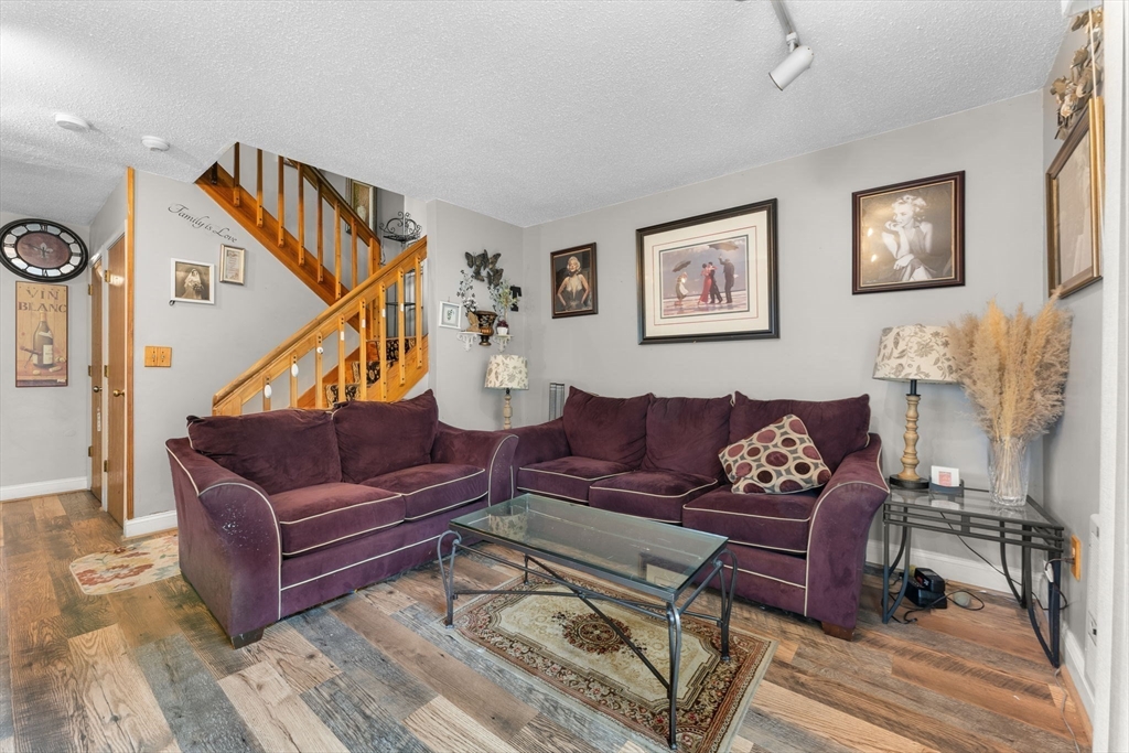 a living room with furniture a rug and a wall painting