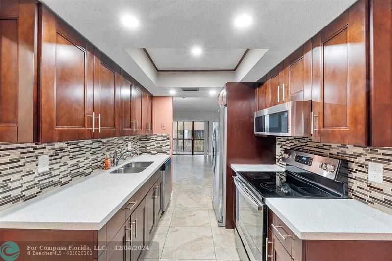 a kitchen with stainless steel appliances granite countertop a stove a sink and a refrigerator