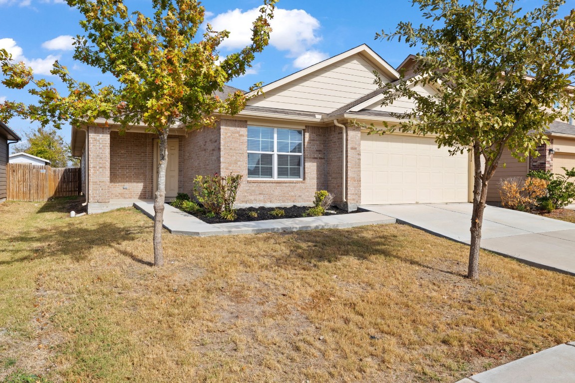 a view of a house with backyard and a tree