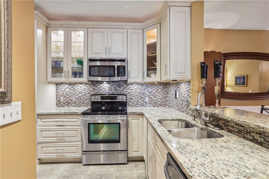 a kitchen with granite countertop a sink stove and cabinets