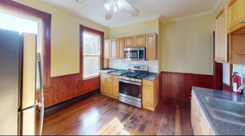 a kitchen with stainless steel appliances granite countertop a stove a sink and a refrigerator