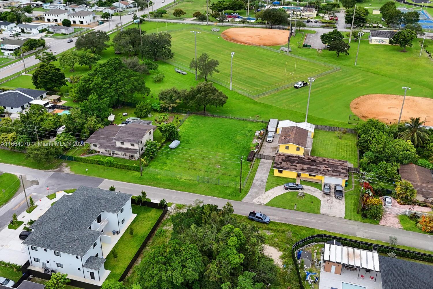 an aerial view of a residential houses with outdoor space and street view