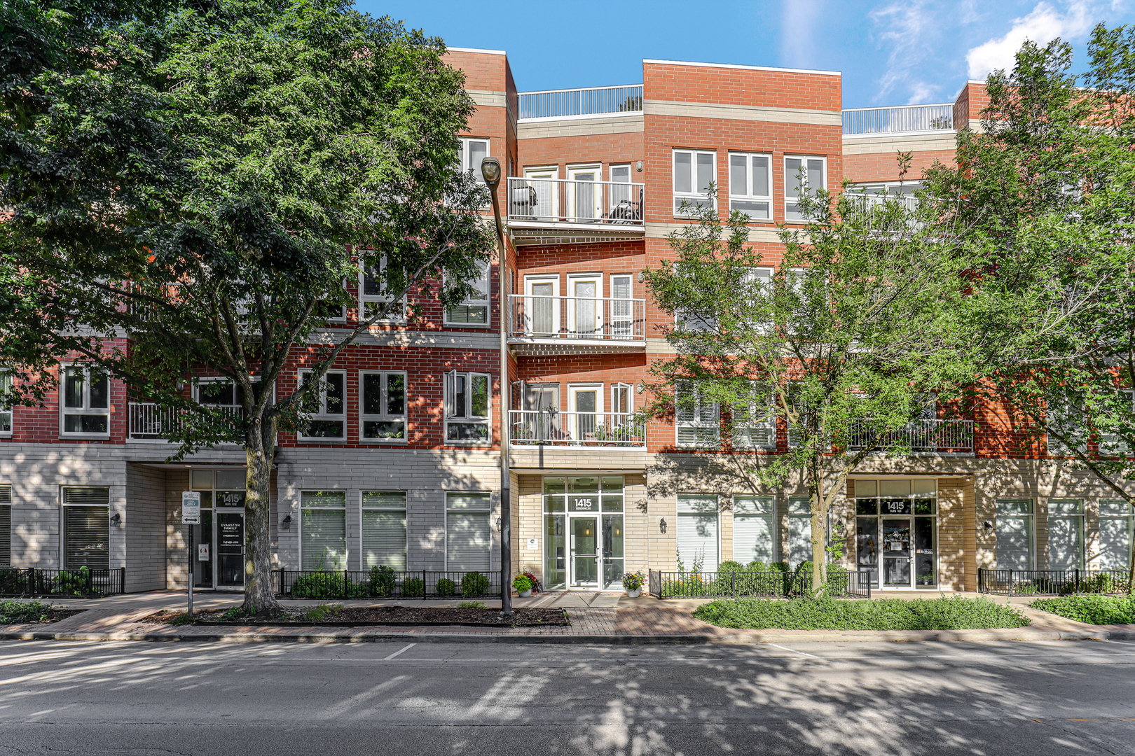 a front view of a multi story building with a yard