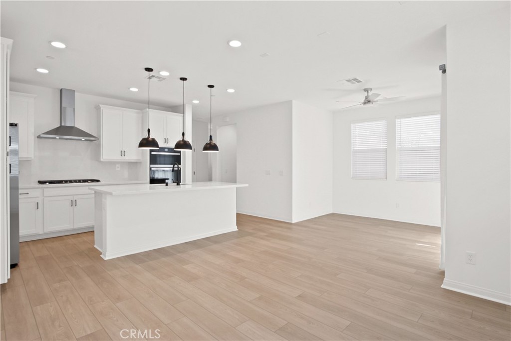 a view of kitchen with kitchen island white cabinets and stainless steel appliances