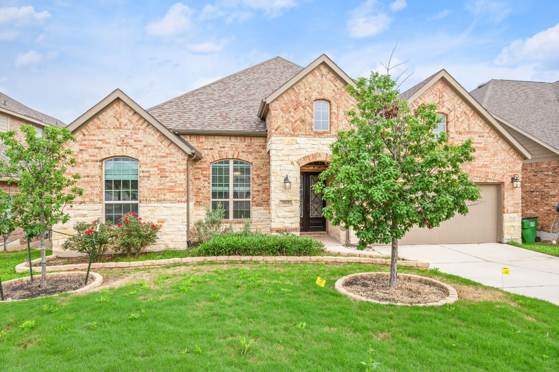 a front view of a house with a yard and trees