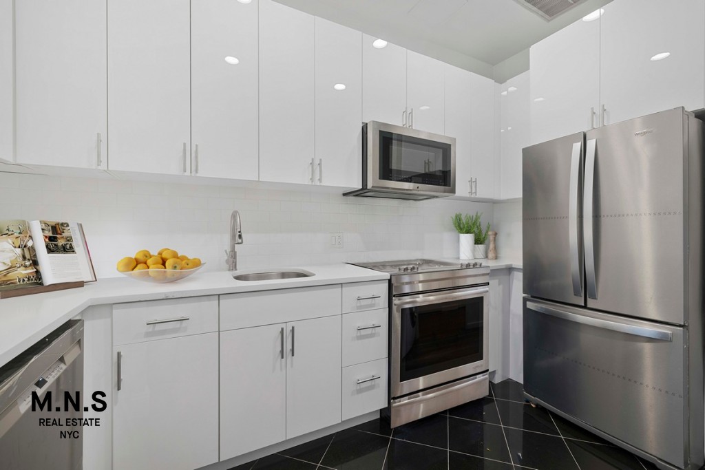 a kitchen with stainless steel appliances a stove microwave and refrigerator