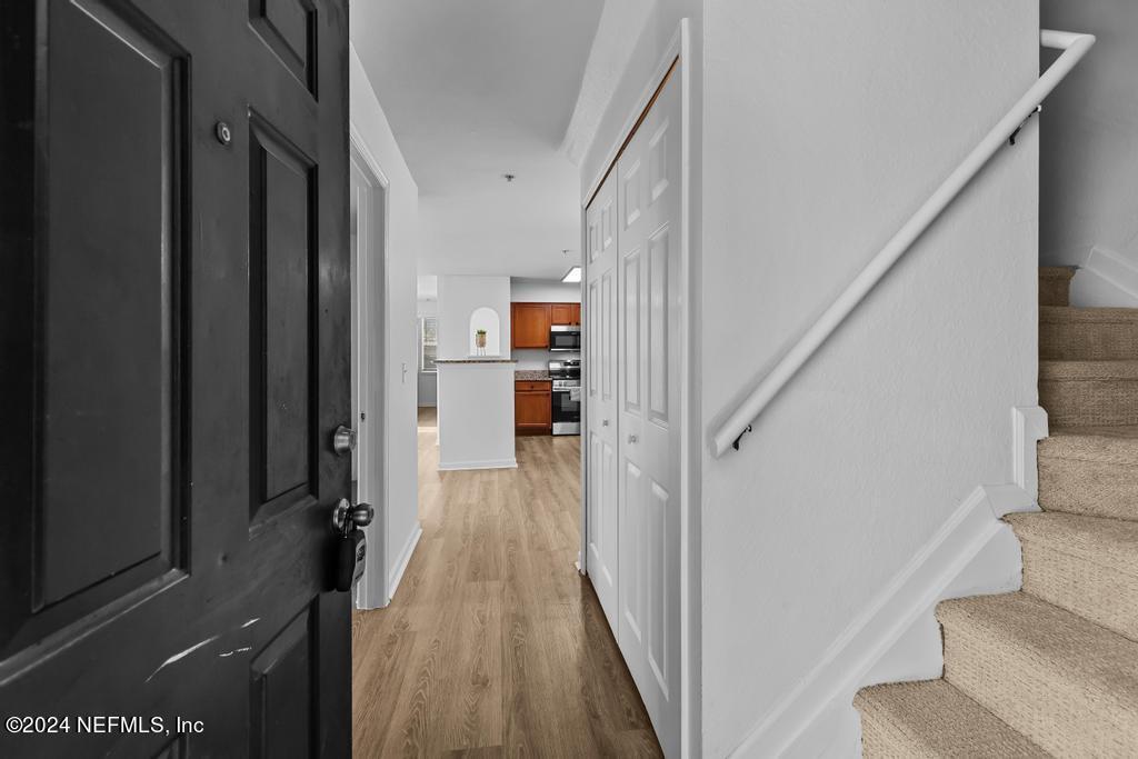 a view of a hallway with wooden floor and staircase