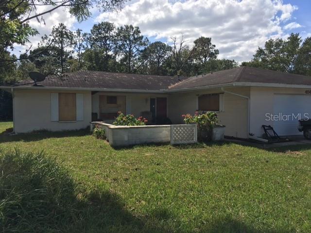 a view of a house with backyard and sitting area