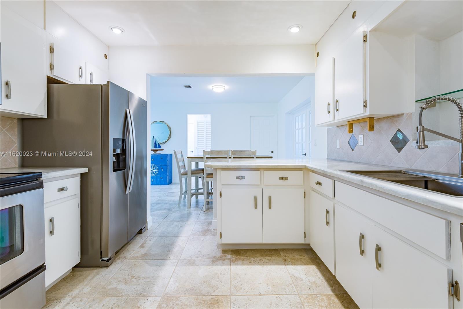 a kitchen with white cabinets and refrigerator