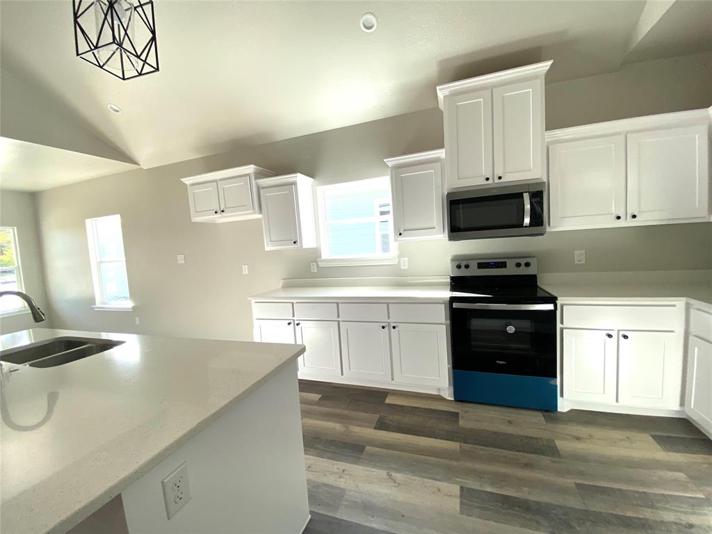 a kitchen with a sink a stove and cabinets