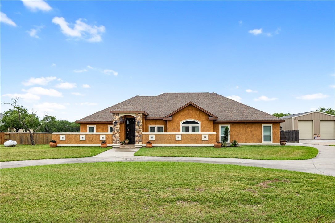 a front view of a house with a garden and yard