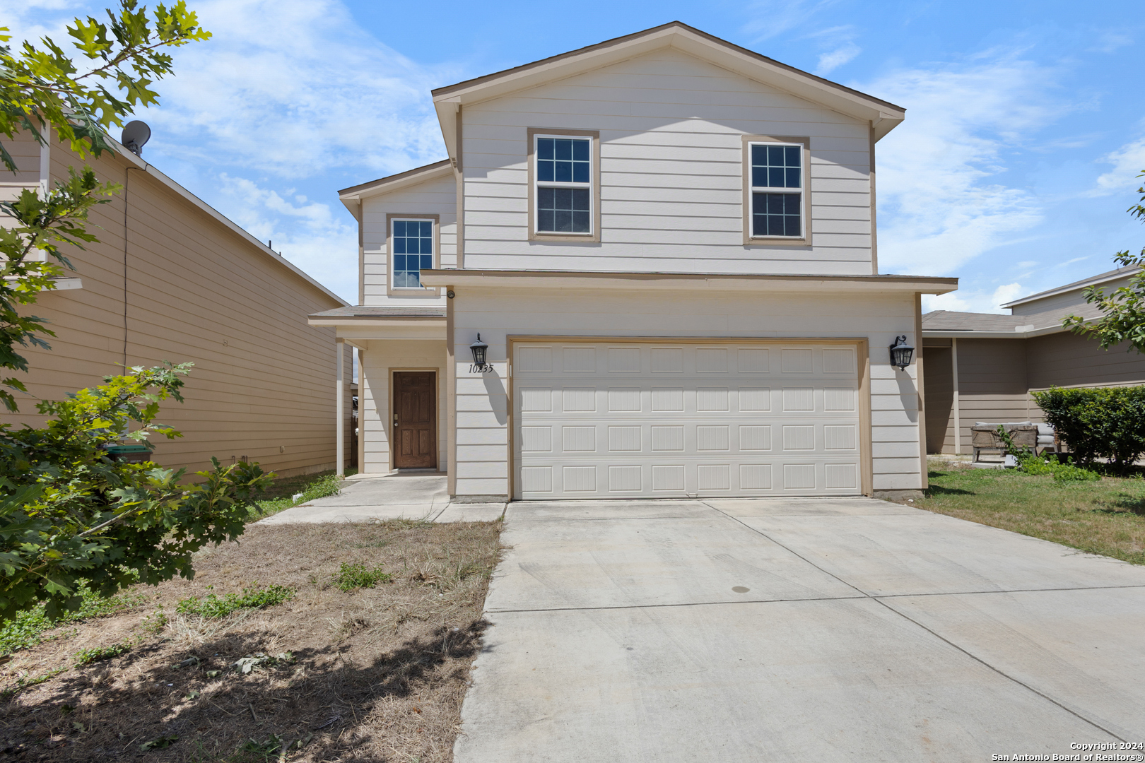 a front view of a house with a yard and garage