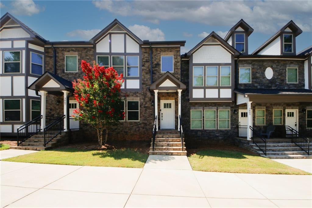 a front view of a house with a yard and potted plants