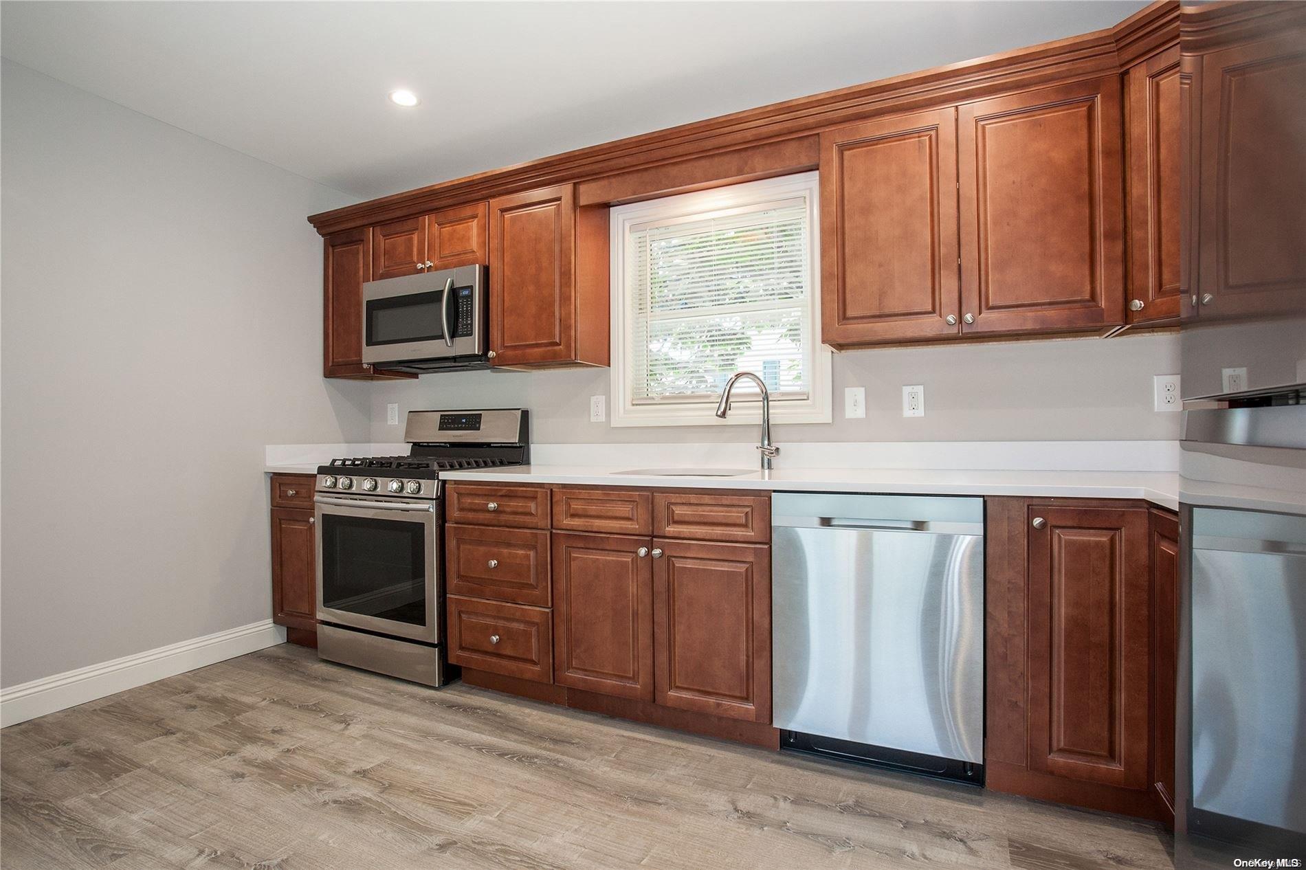 a kitchen with stainless steel appliances granite countertop a stove a sink and a microwave