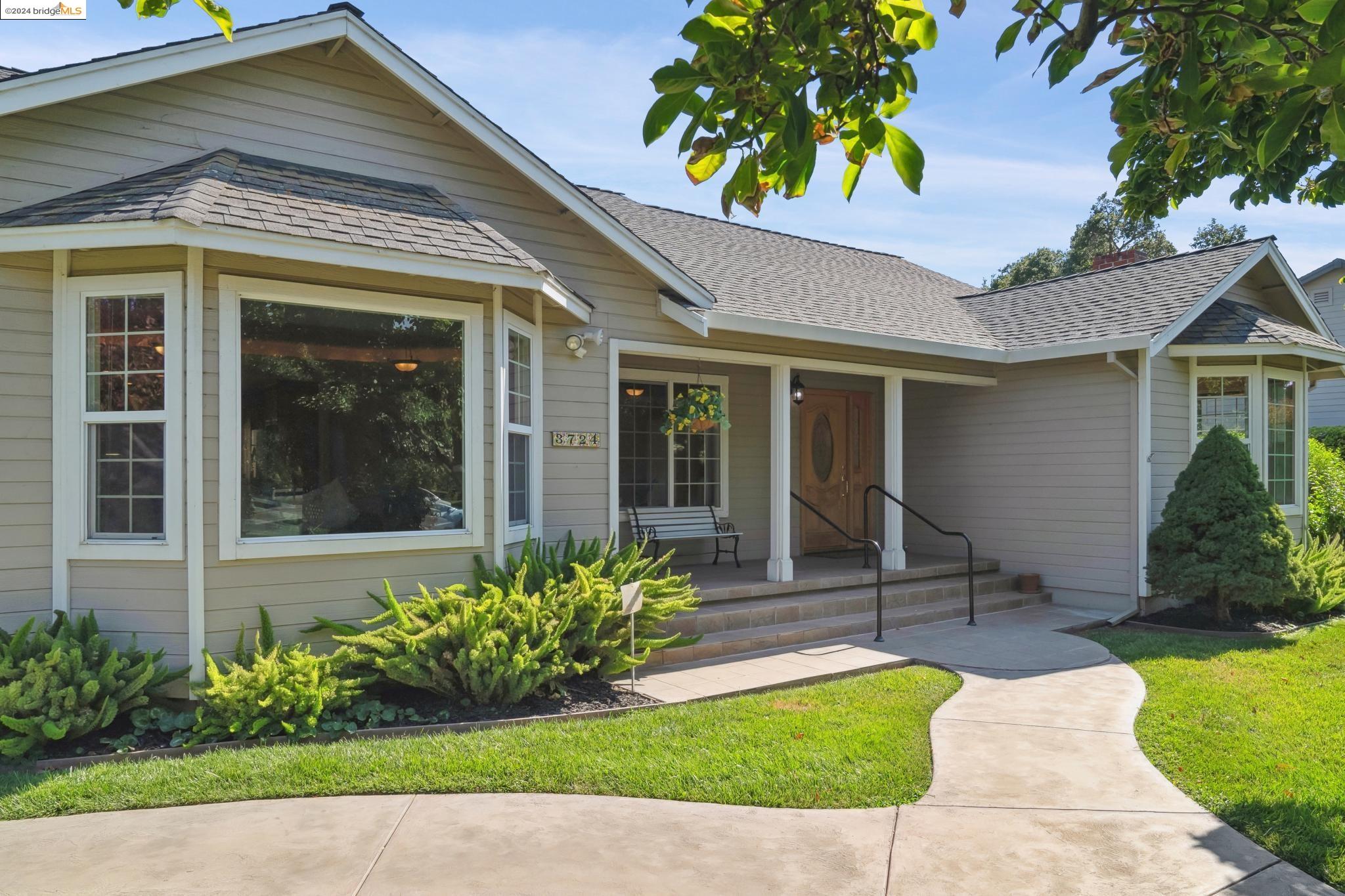 a front view of a house with a yard and potted plants