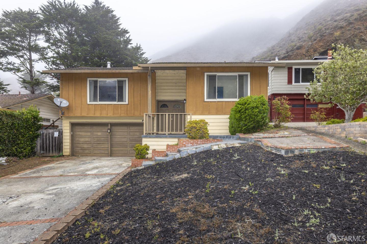 a view of a house with backyard and a tree