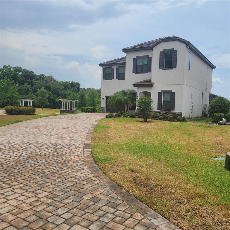 a view of house with yard and sitting area