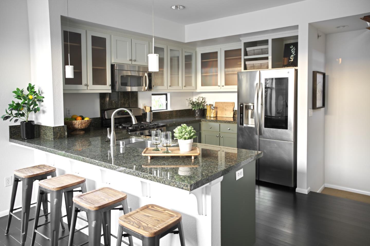 a kitchen with granite countertop a refrigerator a stove and a sink